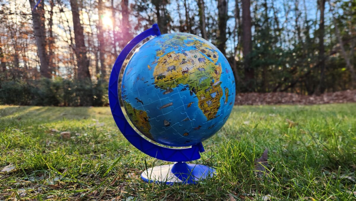 A puzzle globe against the backdrop of nature.